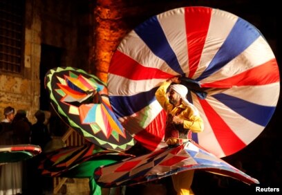 Penari tradisional Mesir menampilkan Tanoura, tarian Sufi versi Mesir, selama bulan suci Ramadhan, di Istana Al Ghouri di kawasan Islam kuno Kairo, Mesir, 7 Juni 2018. (Foto: Reuters)