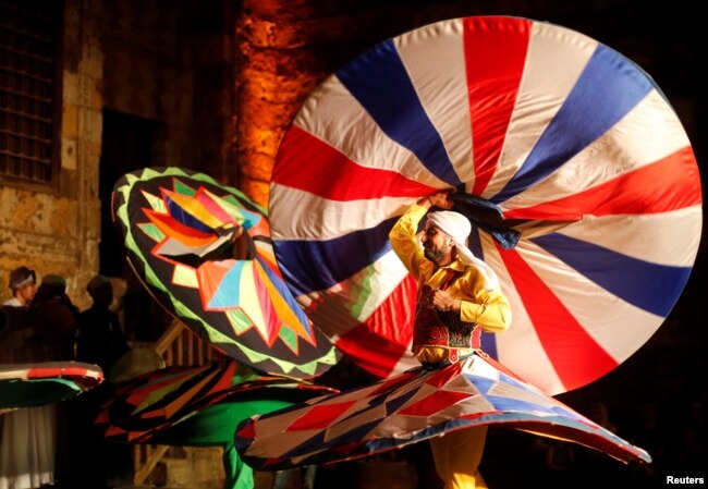 Penari tradisional Mesir menampilkan Tanoura, tarian Sufi versi Mesir, selama bulan suci Ramadhan, di Istana Al Ghouri di kawasan Islam kuno Kairo, Mesir, 7 Juni 2018. (Foto: Reuters)