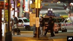 Law enforcement sweep the area after a shooting in downtown Dallas, July 8, 2016.