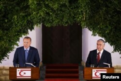 FILE - Turkish President Tayyip Erdogan, left, and Turkish Cypriot leader Mustafa Akinci talk at a news conference during a visit in the Turkish Cypriot northern part of the divided city of Nicosia, Cyprus, July 10, 2018.