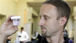 Entomologist Jeff White holds a container of live bed bugs at the North American Bed Bug Summit in Rosemont, Illinois, on September 21