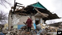 FILE — Liudmyla Momot weeps as she searches for any still-usable items Dec. 10, 2021, in the debris of her house in the village of Nevelske, Ukraine, after it was hit by a mortar shell fired by Russia-backed separatists.