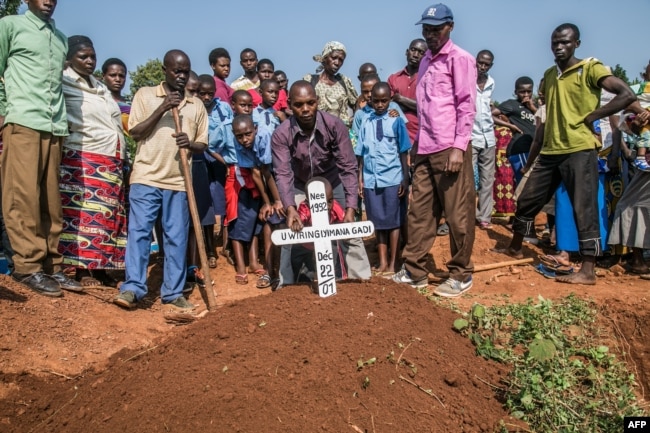 Mourners place a cross on the grave of Uwiringiyimana Gadi, 22, a victim of a collapsed mine, at the Ntunga public cemetery in Rwamagana, eastern Rwanda, on Jan. 22, 2019.