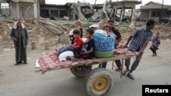 A displaced Iraqi family is transported on a cart as the battle between the Iraqi Counter Terrorism Service and Islamic State militants continues nearby, in western Mosul, April 23, 2017.