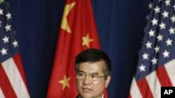 U.S. ambassador to China Gary Locke delivers a speech to the American Chamber of Commerce in the People's Republic of China (AmCham-China) and members of United States-China Business Council, in front of the national flags of U.S. and China, at the Westin