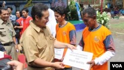 Petugas pemerintah kabupaten Kulonprogo, DI Yogyakarta, memberikan hadiah simbolis yang menyatakan hadiah kambing bagi mereka yang melakukan vasektomi. (VOA/Nurhadi Sucahyo)