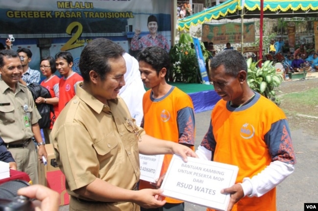 Petugas pemerintah kabupaten Kulonprogo, DI Yogyakarta, memberikan hadiah simbolis yang menyatakan hadiah kambing bagi mereka yang melakukan vasektomi. (VOA/Nurhadi Sucahyo)