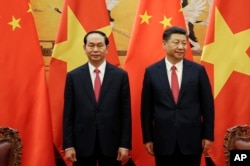 FILE - Vietnamese President Tran Dai Quang, left, and his Chinese counterpart Xi Jinping attend a signing ceremony at the Great Hall of the People in Beijing.