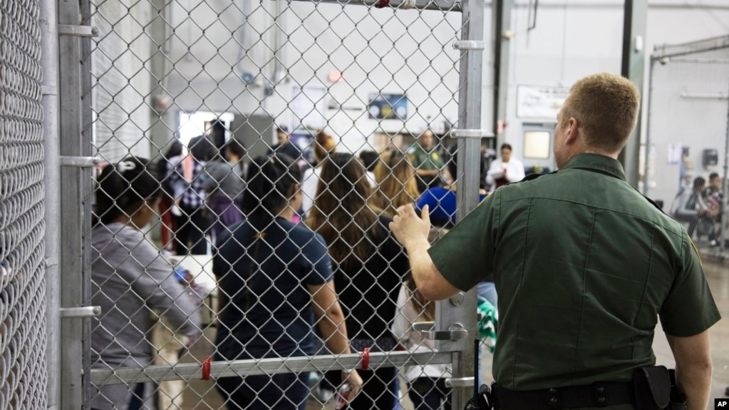 En esta foto suministrada por la Agencia de Aduanas y ProtecciÃ³n Fronteriza de EE.UU., un agente de la Patrulla Fronteriza vigila a gente que ha sido detenida por ingresar ilegalmente al paÃ­s en McAllen, Texas, el domingo, 17 de junio de 2018.