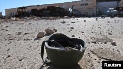 FILE - A helmet belonging to an Islamic State militant is seen on the ground in the town of al-Melabiyyah, south of Hasaka city, Syria, Nov. 24, 2015.