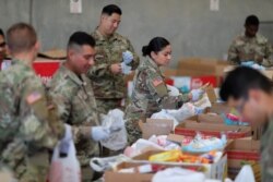 Pasukan Garda Nasional California menyiapkan paket bantuan makanan untuk bantuan makanan para lansia di tengah wabah virus corona, di Indio, California, 26 Maret 2020. (Foto: Reuters)