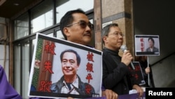 1月19日，在香港的中联办外，香港倡导民主的公民党抗议者们手持失踪书商李波和桂民海的照片。