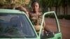 Bibata Gansgne, conductrice de taxi dans la capitale burkinabè pose à côté de son taxi dans les rues de Ouagadougou, le 1er mai 2018.