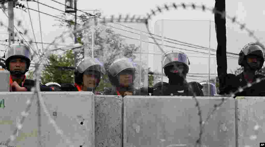 Riot police stand guard behind barricades during an anti-government rally in Bangkok, Nov. 26, 2013. 