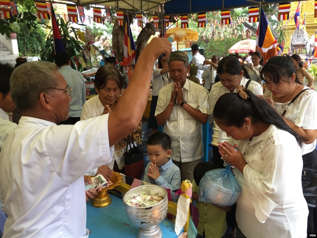 ពុទ្ធ​បរិស័ទ​កំពុង​ឈរ​ទទួល​ពរ​នៅ​ក្នុង​វត្ត​មួយ​កណ្តាល​រាជធានី​ភ្នំពេញ​កាលពី​ព្រឹក​ថ្ងៃសៅរ៍​ ទី​១៦ ខែ កញ្ញា​​ ឆ្នាំ២០១៧។​(កាន់​វិច្ឆិកា/VOA)