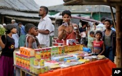 In this photograph taken Aug. 27, 2018, a Rohingya man looks at medicines being sold on the roadside in Balukhali refugee camp, Bangladesh. (AP Photo/Altaf Qadri)