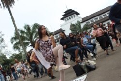 Seratusan peserta IWD Bandung melakukan tari 'One Billion Rising' yang menyuarakan perlawanan terhadap kekerasan seksual. (VOA/Rio Tuasikal)