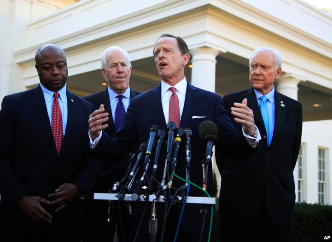 FILE - Then-Senator Patrick Toomey, R-Pa., second from right, speaks to reporters in Washington, Nov. 27, 2017.