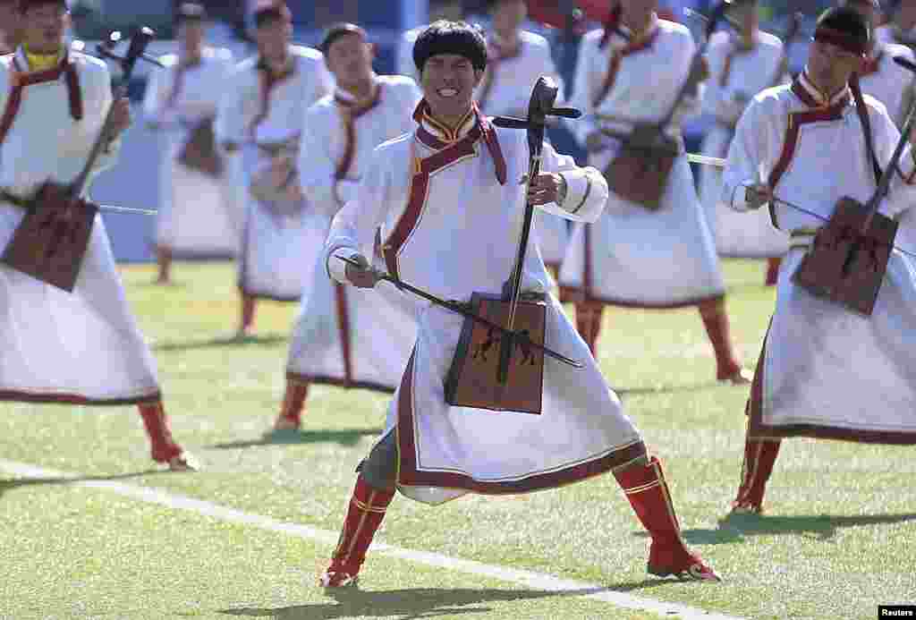 Participants play traditional Mongolian instruments during a performance at the opening ceremony of Nadam Fair in Xilinhot, Inner Mongolia Autonomous Region.