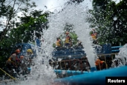 Rescue workers work next to water pumped out of the Tham Luang cave complex, where members of an under-16 soccer team and their coach have been found alive, in the northern province of Chiang Rai, Thailand, July 5, 2018.