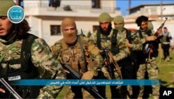 FILE - This file photo posted on the Twitter page of Syria's al-Qaida-linked Nusra Front on April 1, 2016, shows fighters from al-Qaida's branch in Syria, the Nusra Front.