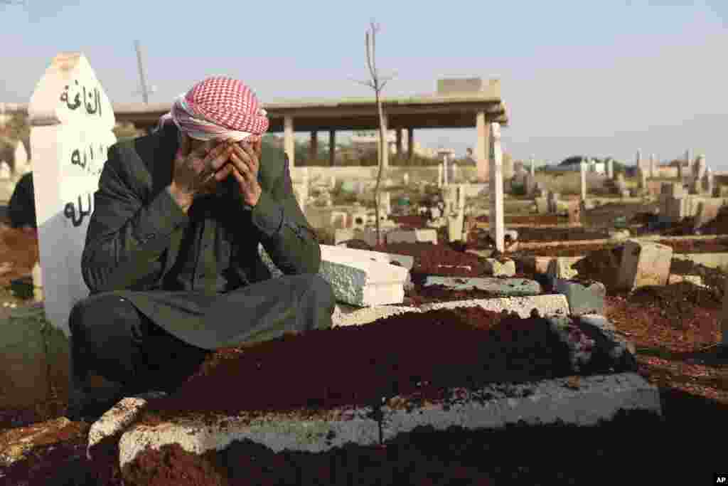 Mohammad al-Mahmoud, father of a seven-day-old baby, Fatima, cries at her grave in Haranbush village, Idlib province, Syria.&nbsp;Doctors say Fatima died from cold after she was brought to a hospital from a refugee camp near the village of Haranbush.