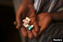 FILE - Nine-year-old Tumelo takes antiretroviral pills before at Nkosi's Haven, south of Johannesburg, Nov. 28, 2014. Nkosi's Haven provides residential care for destitute HIV-positive mothers and their children.