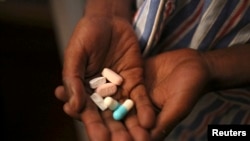 Nine-year-old Tumelo shows off antiretroviral (ARV) pills before taking his medication at Nkosi's Haven, south of Johannesburg, in 2014. 