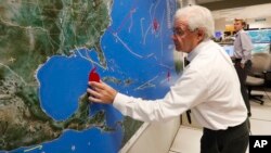 National Oceanic and Atmospheric Administration public affairs officer Dennis Feltgen updates the progress of Hurricane Michael on a large map, Oct. 9, 2018, at the Hurricane Center in Miami. 