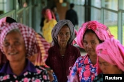 FILE - Women arrive at the entrance to the Extraordinary Chambers in the Courts of Cambodia for a trial hearing about evidence of forced marriage and rape during the Khmer Rouge regime, on the outskirts of Phnom Penh, Cambodia, Aug. 23, 2016.