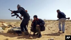 Rebel fighters survey the situation during a battle along the road between Ras Lanuf and Bin Jiwad, Libya, March 10, 2011