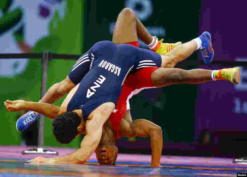 Togrul Asgarov (kiri) dari Azerbaijan dan Frank Chamizo Marquez dari Italia memperebutkan medali emas di gulat bebas putra 65 kg di European Games pertama di Baku, Azerbaijan.