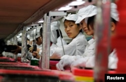 FILE - Workers are seen at a Foxconn factory in Longhua, Guangdong province, China, May 26, 2010. Foxconn is Apple's main supplier of iPhones.