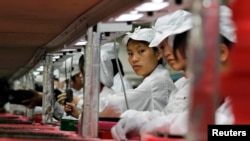 Các công nhân làm việc ở nhà máy Foxconn, chuyên sản xuất linh phụ kiện cho Apple, ở Quảng Đông, Trung Quốc. Foxconn đang tìm cách chuyển dây chuyền sản xuất sang Việt Nam.