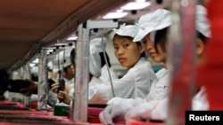 FILE - Workers at a Foxconn factory in Longhua, Guangdong province, China, May 26, 2010. Foxconn is Apple's main supplier of iPhones.