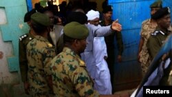 L'ancien président soudanais Omar el-Béchir est escorté lors de sa sortie de la prison nationale de Khartoum, le 16 juin 2019.