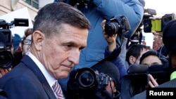FILE - Former U.S. national security adviser Michael Flynn passes by members of the media as he departs after his sentencing was delayed at U.S. District Court in Washington, Dec. 18, 2018. 