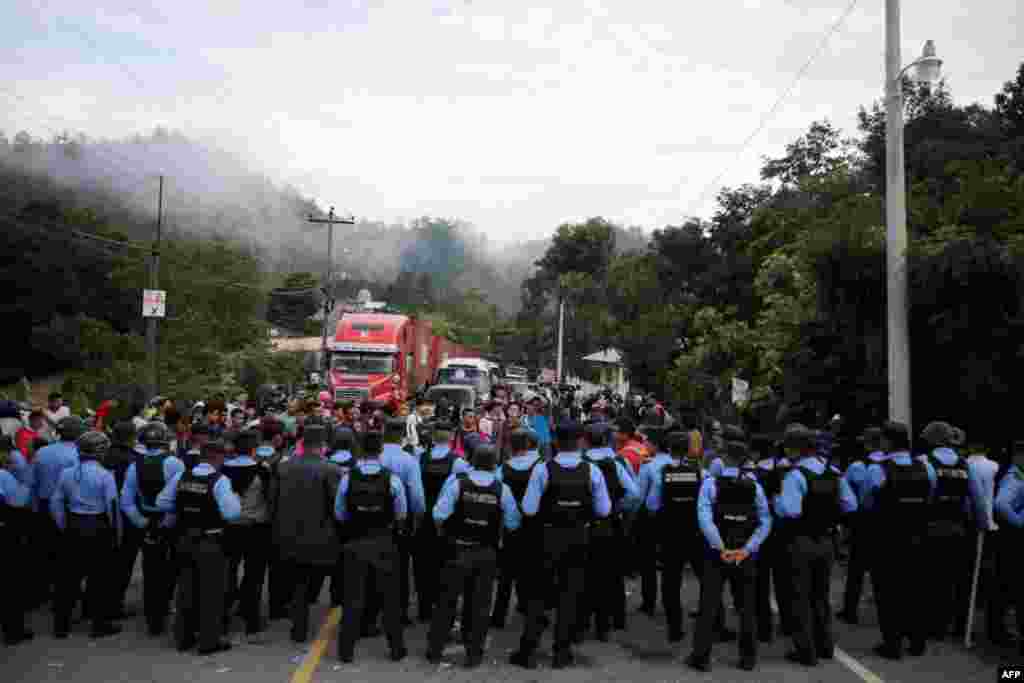 Oficiales de policía hondureños bloquean el acceso a la frontera Agua Caliente con Guatemala mientras que migrantes hondureños tratan de unirse a una caravana que se dirige hacia EE.UU., en la municipaliad de Ocotepeque, en Honduras, el 19 de octubre del 