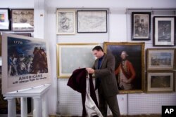 In this June 5, 2014 photo, Scott Stephenson, Director of Collections and Interpretation, uncovers the recently conserved George Washington's flag.