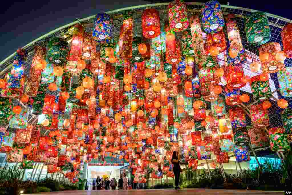 A woman takes a selfie under festive decorations for the upcoming Lunar New Year outside a shopping mall in Bangkok, Thailand.