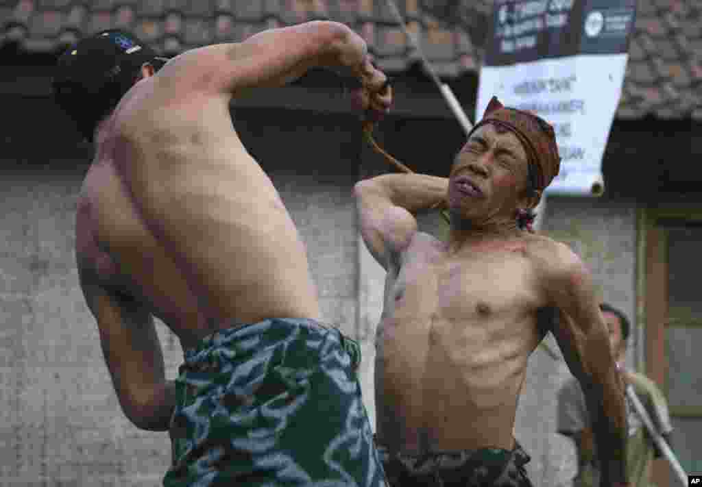 Tengger tribesmen perform cane fighting during the religious ritual of "Karo" in Probolinggo, East Java, Indonesia. The Hindu tribe celebrate the ritual once a year to praise their God, Sang Hyang Widi Wasa, who endows prosperity to their land.