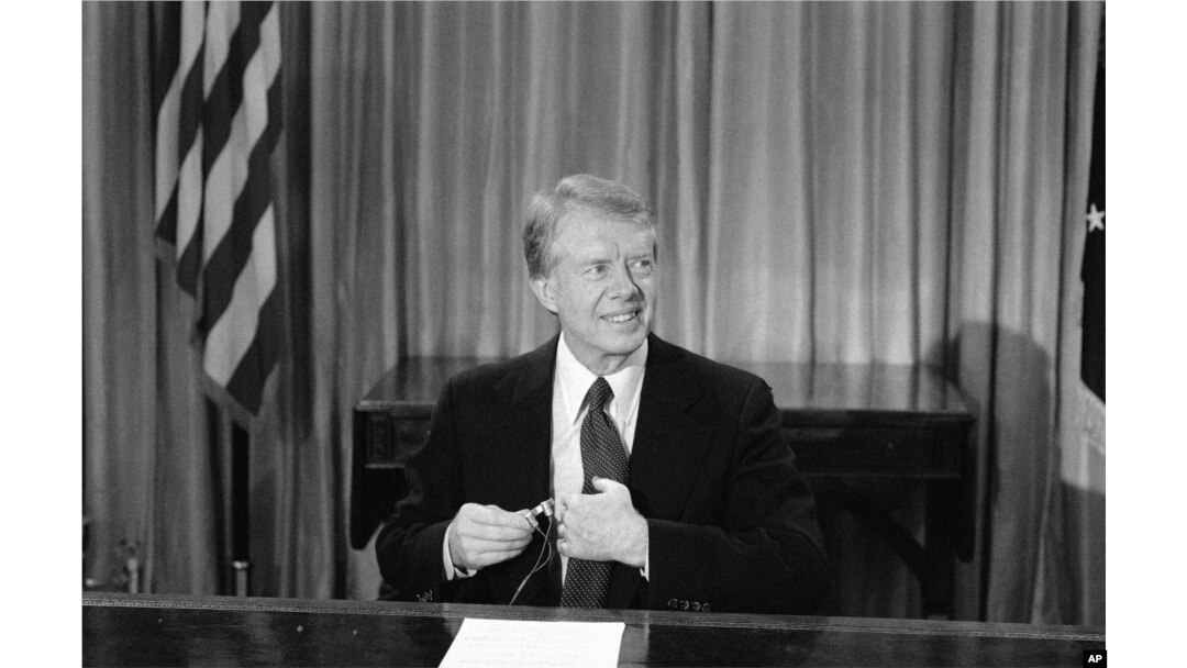 Presiden Jimmy Carter menyesuaikan mikrofon sebelum muncul di televisi dari Kantor Oval di Washington pada hari Jumat, 10 Desember 1978. (Foto: AP)
