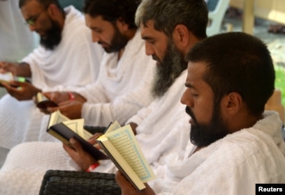 Delapan Muslim dari Inggris yang bersepeda dari London ke Madinah untuk menunaikan ibadah Haji, membaca Alquran di tenda mereka di Arafah, 10 Agustus 2019.