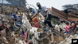 Des responsables gouvernementaux de l'Organisation standard du Nigéria examinent les matériaux utilisés dans la construction du bâtiment qui s'est effondré à Lagos, au Nigéria, le 14 mars 2019.