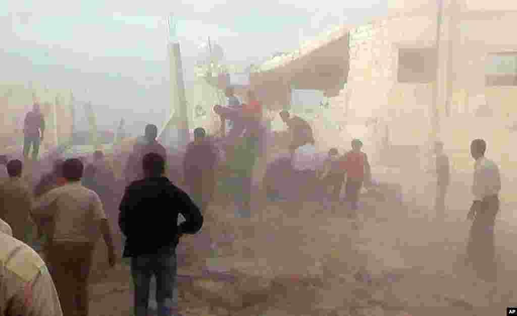 صوبے ادلیب میں فضائی حملے کا نشانہ بننے والی ایک عمارت کے پاس لوگوں کا ہجوم