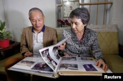 Former Vietnamese chemical student Pham Ngoc Canh who studied in North Korea and his North Korean wife Ri Yong Hui looks at their wedding photos, at their house in Hanoi, Vietnam February 12, 2019. (REUTERS/Kham)