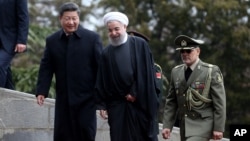 Chinese President Xi Jinping, left, is welcomed by Iranian President Hassan Rouhani during his official arrival ceremony at the Saadabad Palace in Tehran, Iran, Jan. 23, 2016. 