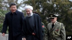 Chinese President Xi Jinping, left, is welcomed by Iranian President Hassan Rouhani during his official arrival ceremony at the Saadabad Palace in Tehran, Iran, Jan. 23, 2016. 