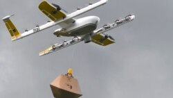 In this Tuesday, Aug, 7, 2018, photo a Wing Hummingbird drone carries a package of ice cream and popsicles as it leaves its launch site during a delivery flight demonstration in Blacksburg, Va. (Michael Shroyer via AP)