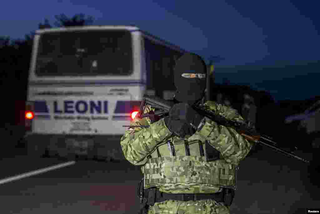 A Ukrainian serviceman secures the area during an exchange of prisoners-of-war near Donetsk, eastern Ukraine, Sept. 21, 2014. 